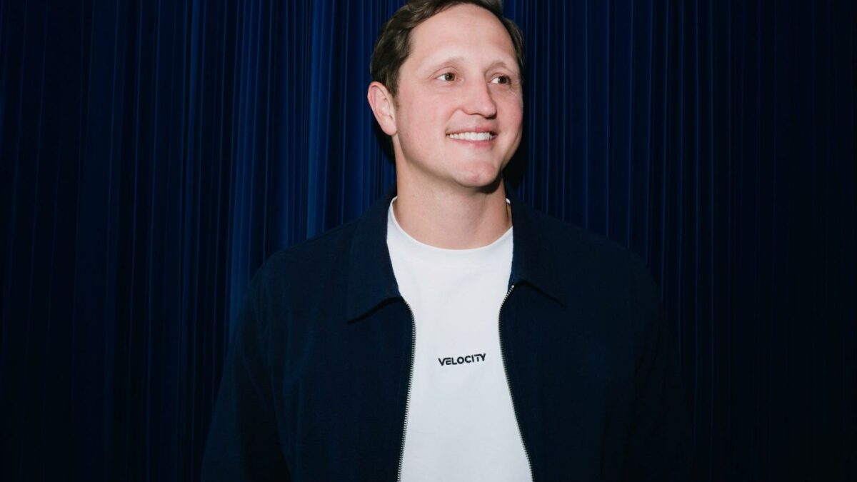 Velocity CEO Eric Queathem smiles as he looks to the far left.