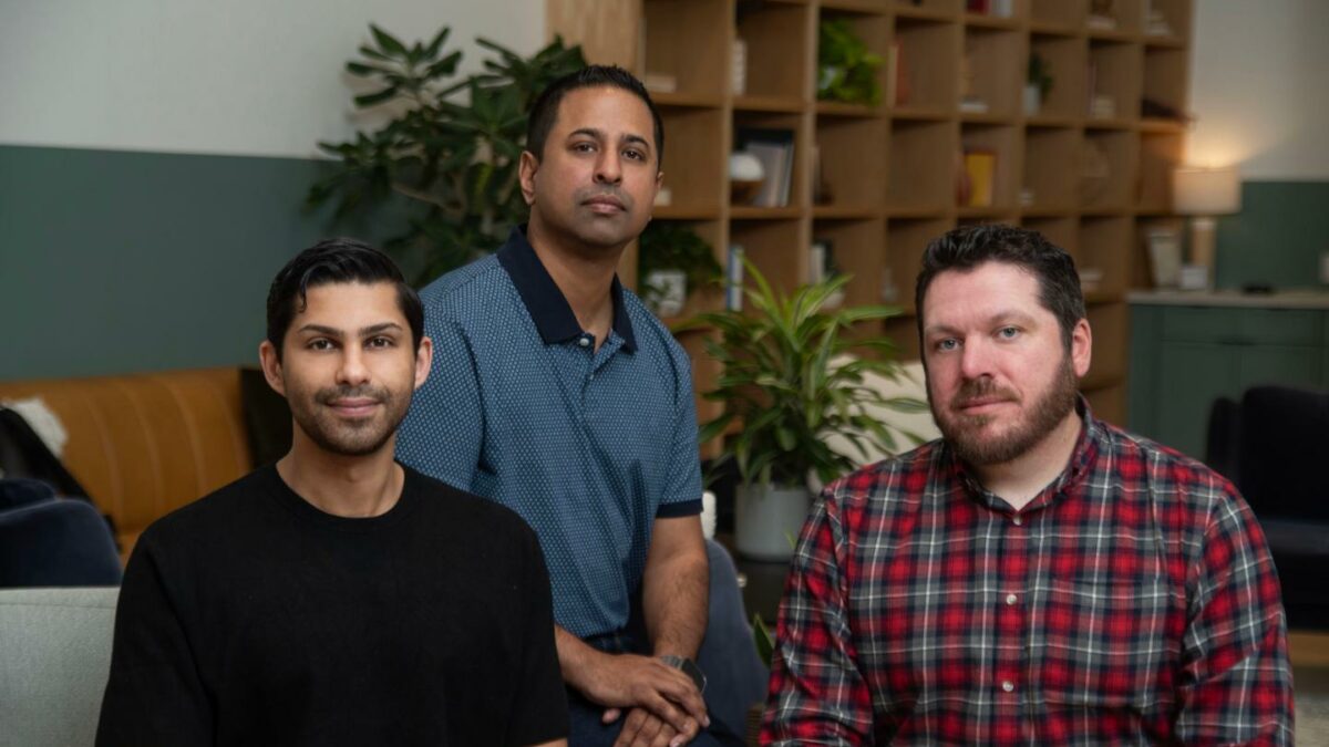 three men pose for camera