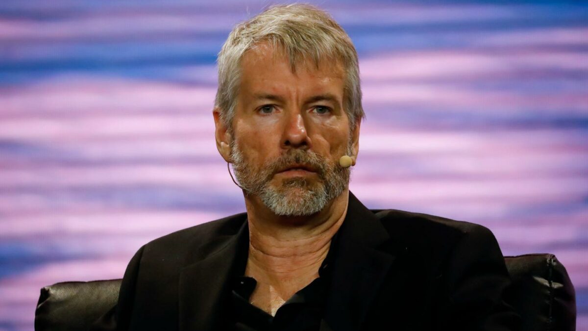 Strategy executive chairman Michael Saylor wears a microphone and looks into the crowd during a conference.
