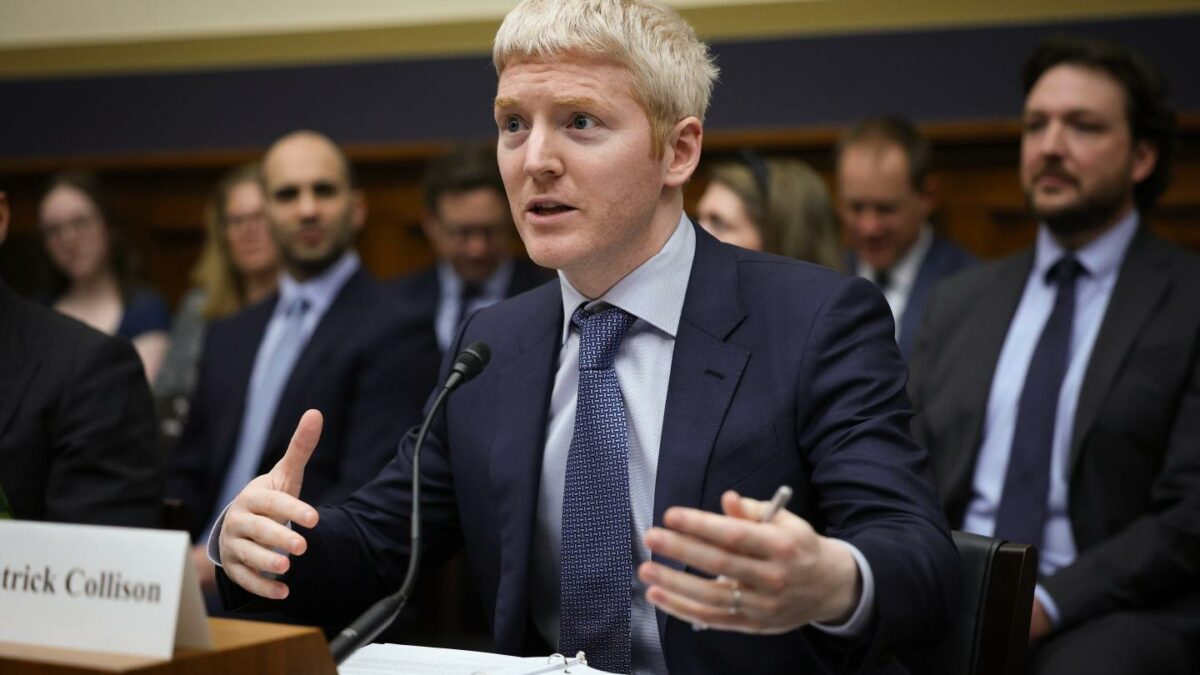 Stripe CEO Patrick Collison gestures with his hands as he speaks into a microphone before a congressional committee hearing.