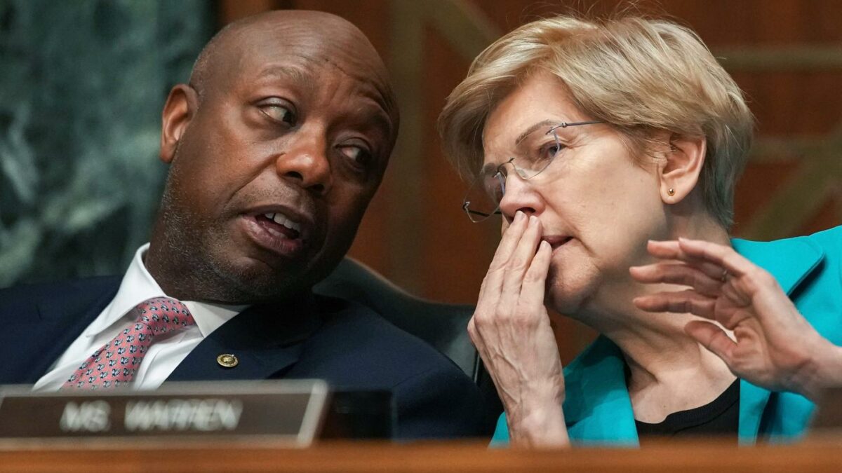 Sens. Tim Scott (R-S.C.) and Elizabeth Warren (D-Mass.) whisper to each other during a Senate committee meeting